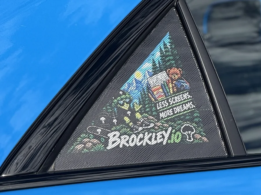 The Brockley.io sticker on the quarter window of a blue Cadillac